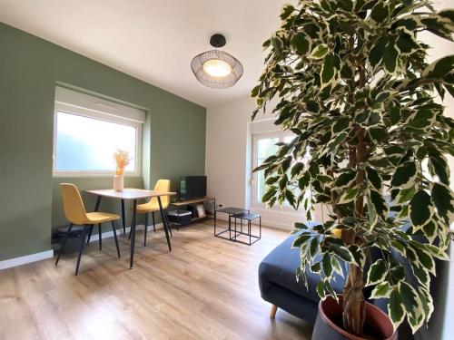 a living room with a table and a potted plant at Appartements avenue général Leclerc in Vienne