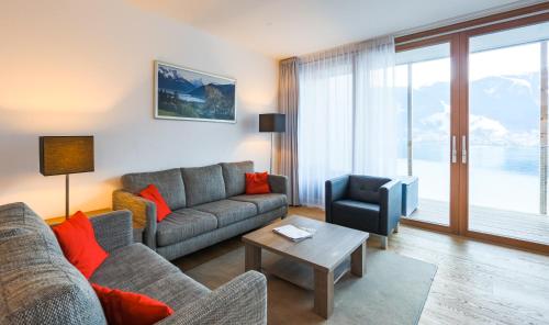 a living room with a couch and a chair at Residence Bellevue - incl Summercard in Zell am See