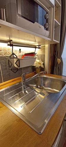 a stainless steel sink in a kitchen with a microwave at La Loge Du Vieux Lyon in Lyon