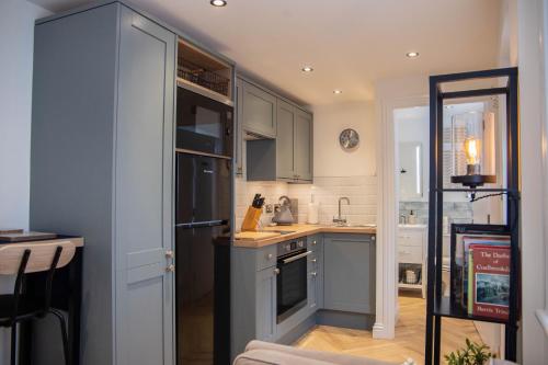 a kitchen with blue cabinets and a stove top oven at The Coracle in Ironbridge