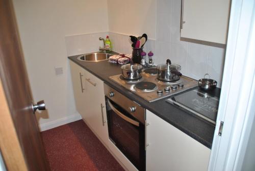 a small kitchen with a stove and a sink at The Studios, Dedworth Road, by Accommodation Windsor in Windsor