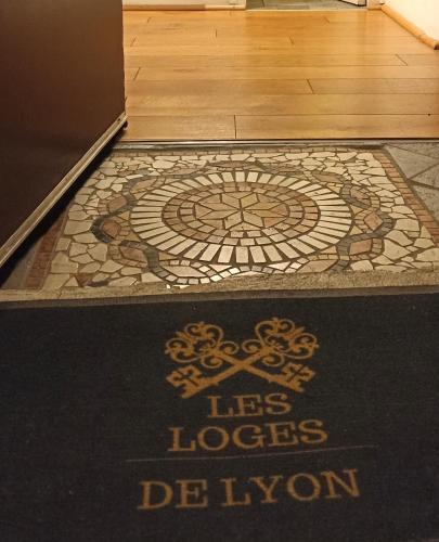 a tiled floor with a welcome mat in a room at La Loge Du Vieux Lyon in Lyon
