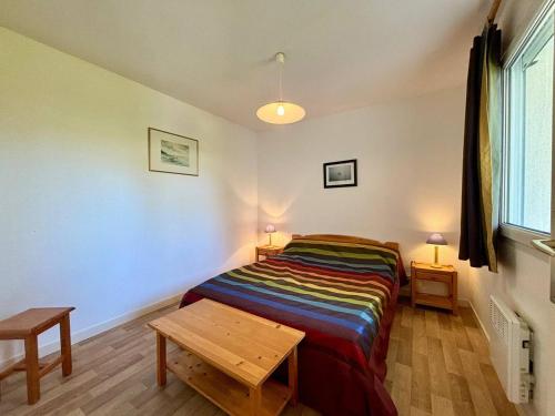 une chambre avec un lit et une table dedans dans l'établissement Appartement 2 pièces avec jardin, calme, proche plage et commerces, parking privé inclus, Carnac - FR-1-377-33, à Carnac