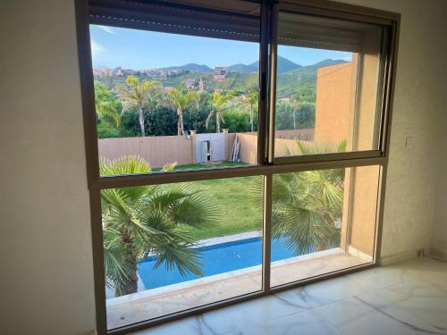 a room with a window looking out at a pool at MARRAKECH , Ourika in Ourika