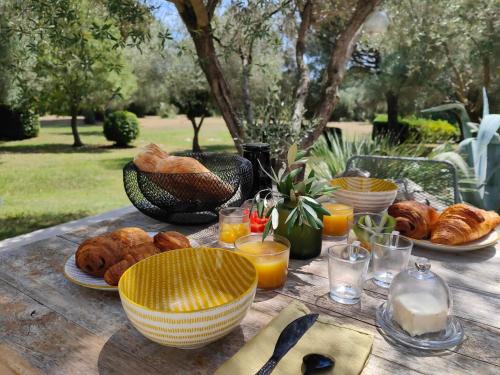 a table with plates of bread and glasses of orange juice at La Maison l'Oliveraie in Lunel