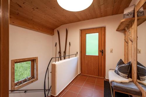 a hallway with a wooden door and a chair at Chalet der Erzstadl in Kirchberg in Tirol