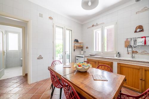 een keuken met een houten tafel en rode stoelen bij Valdemare Relax&Beach in Ostuni