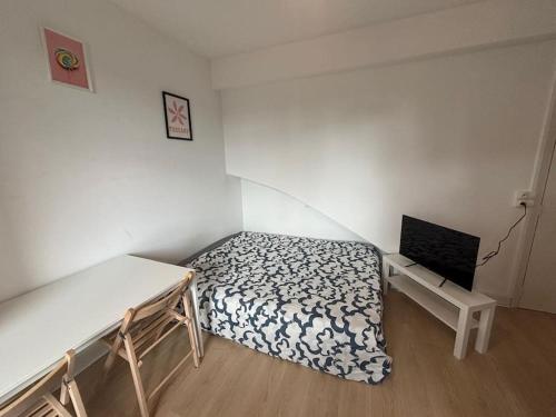 une petite chambre avec un lit et une table dans l'établissement Tuscany - Charmant Studio, à Toulouse