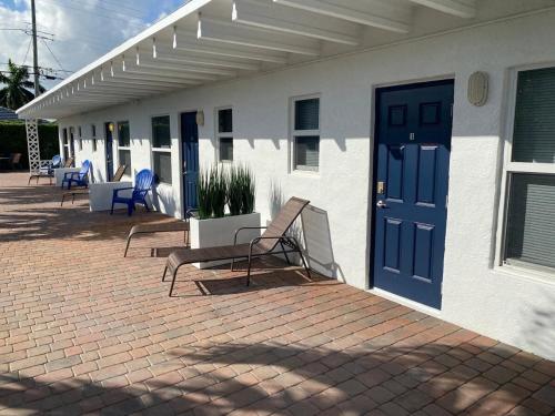 a patio with two benches and a blue door at 2 Min Walk To The Beach- Renovated King Studio #2 in Fort Lauderdale