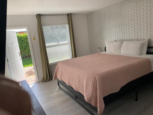 a bedroom with a bed and a large window at 2 Min Walk To The Beach- Renovated King Studio #2 in Fort Lauderdale