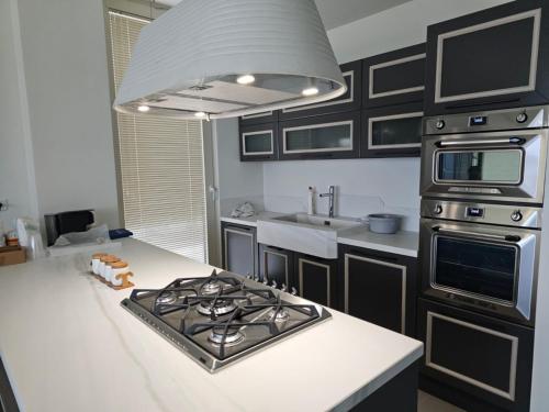 a kitchen with a stove and a white counter top at Villa Ostriche Green Coast Palase in Palasë