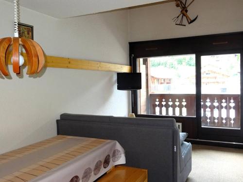 un salon avec un canapé et une fenêtre dans l'établissement Grand studio duplex lumineux - 6 pers - centre Les Gets - parking privé - à 400 m des pistes - FR-1-802-37, aux Gets