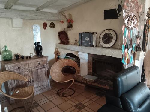 - un salon avec une cheminée et une chaise dans l'établissement Bohémienne, à La Celle-sous-Gouzon