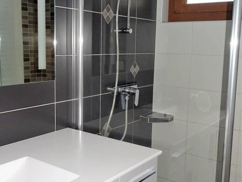 La salle de bains est pourvue d'une douche et d'un lavabo blanc. dans l'établissement Appartement 4 pièces pour 8 pers. avec garage, proche commerces et remontées mécaniques - FR-1-802-57, aux Gets