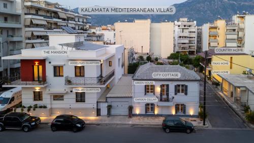 a building with two cars parked in a parking lot at Tinas Home - Kalamata Mediterranean Villas in Kalamata