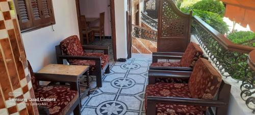 a set of stairs with chairs and a table at Villa El kheer in `Ezbet el-Dabdûba