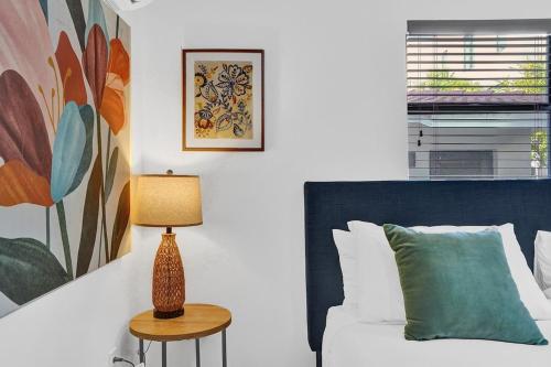 a bedroom with a bed and a table with a lamp at Waves On Walnut - Beach Access in Hollywood