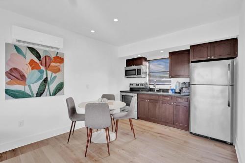a kitchen with a table and chairs and a refrigerator at Waves On Walnut - Beach Access in Hollywood