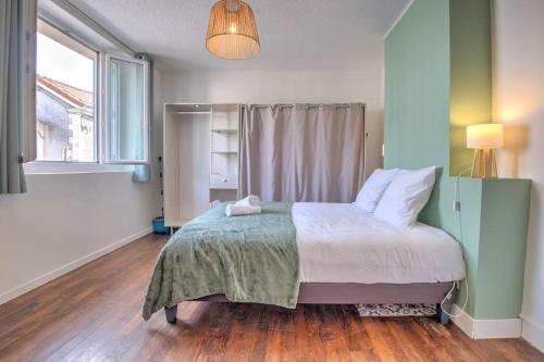 a bedroom with a bed and a large window at L échappée verte in Périgueux