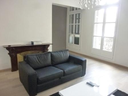 un salon avec un canapé noir et une table dans l'établissement Appartement centre historique place Jean Jaurès climatisé 6 couchages avec parking, à Montpellier