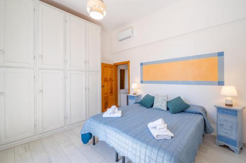 a bedroom with a blue bed with towels on it at Piombino Apartments Casa De Amicis in Piombino