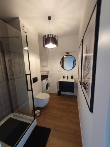 a bathroom with a toilet and a sink and a mirror at City Lux Apartament Free Parking in Leszno