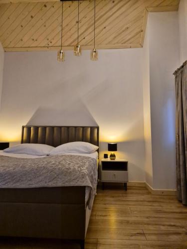 a bedroom with a large bed and a wooden floor at Apartament z prywatna wanną hydromasaż - U Parów in Białka Tatrzanska