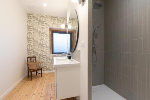 une salle de bain avec un lavabo et un miroir dans l'établissement Cabana & Le Pressoir Doré, à Lacenas