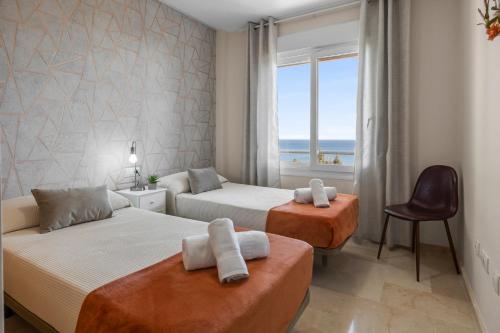 una camera da letto con due letti e vista sull'oceano di Breathtaking terrace by Costarentals - Ref M45 a Manilva