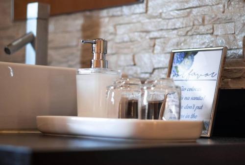 a white plate with a bottle of soap and a sign at English house in Ponta Delgada