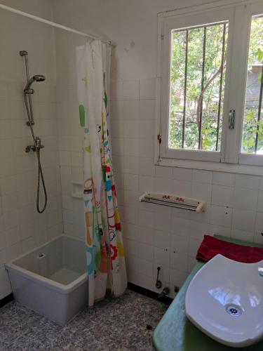 une salle de bain avec une baignoire, un lavabo et une douche dans l'établissement Charming little house, sea view and big terrace, à Roquebrune-Cap-Martin