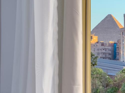 a view of the pyramids from a window of a hotel at Royal Crown Hotel Giza Pyramids View in Cairo