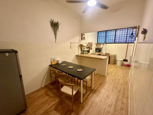 a small room with a table and a kitchen at JPO Camping Style NineInn Homestay in Kulai