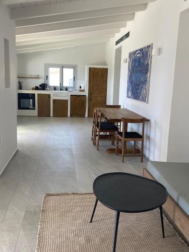 a living room with a table and a kitchen at Evia Bay Suites and Retreats in Edipsos