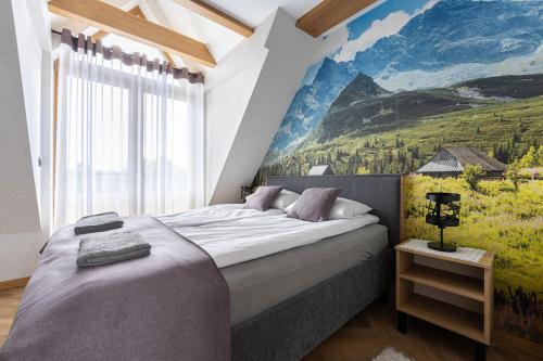 ein Schlafzimmer mit einem großen Bett mit einem Gemälde an der Wand in der Unterkunft Golden Apartments Zakopane - Mountain View in Zakopane