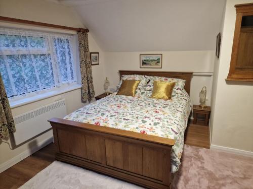 a bedroom with a bed and a window at Woodvale Bungalow in Little Haven