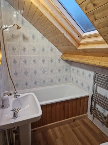 a bathroom with a sink and a bath tub at Woodvale Bungalow in Little Haven