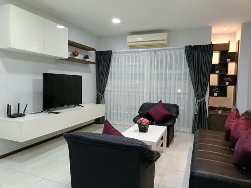 a living room with a couch and a tv at Central Patong apartment at Phuket Villa in Patong Beach