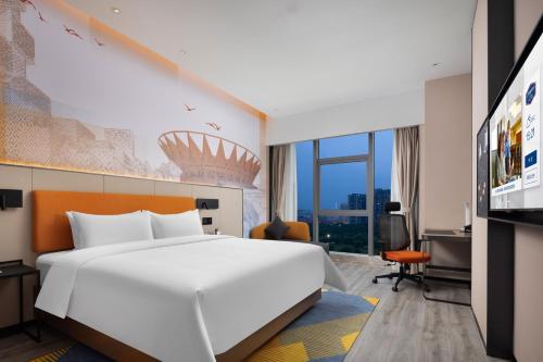 佛山市にあるHampton By Hilton Foshan Shunde Chencunの大きなベッドとテレビがあるホテルの部屋