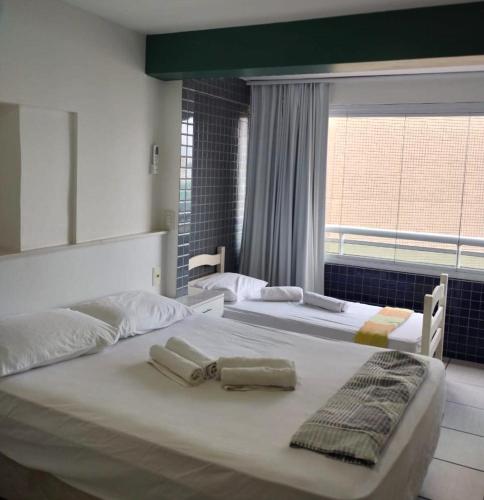 two white beds in a room with a window at Apartamento Em Fortaleza De Frente Para O Mar in Fortaleza