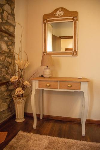 a dressing table with a mirror and a lamp on it at Villa Dionisos in Skotína