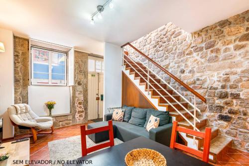 a living room with a stone wall at Casa da Sé Historic next to Braga Cathedral by Sé Apartamentos in Braga