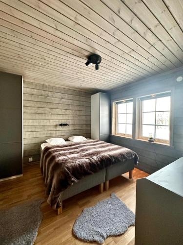 a bedroom with a large bed and a wooden ceiling at Mountain Birch - Fjäll Bjorken in Åre