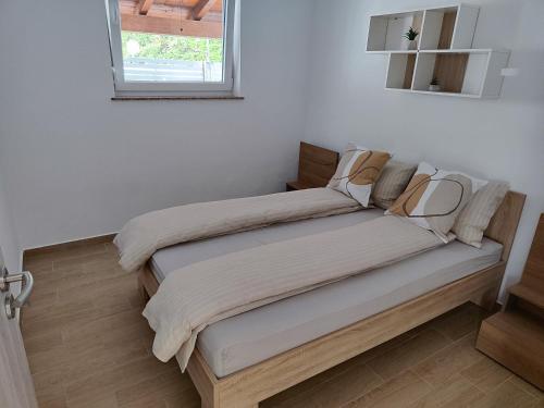 a bed in a white room with a window at Apartment Rose in Marezige