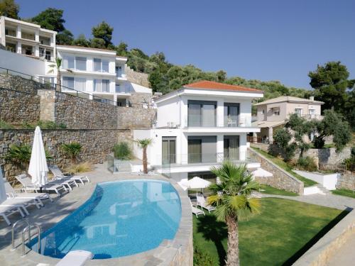 a villa with a swimming pool next to a building at Hillside Villa - Pnoe in Limenas