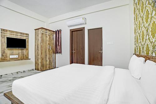 a bedroom with a white bed and a television at Collection O Verena in Indore