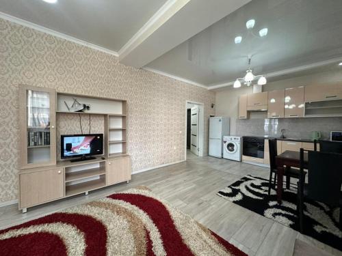 a large living room with a television and a kitchen at Diamond city in Bishkek
