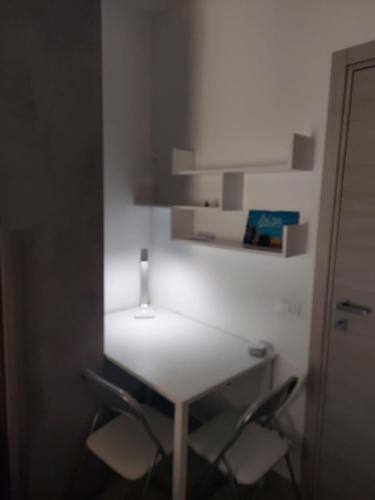 a white table with two chairs and a lamp on it at Bergamo - La Casa Di Gianna in Nembro