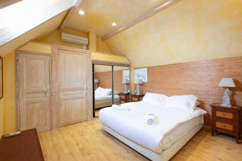 a bedroom with a large white bed in a room at Le Clos des Vignes in Loisy
