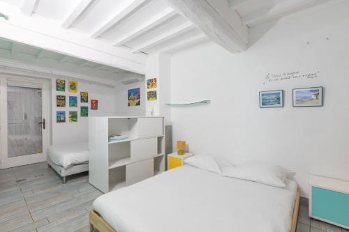 a white bedroom with a bed and a shelf at Le Clos des Vignes in Loisy
